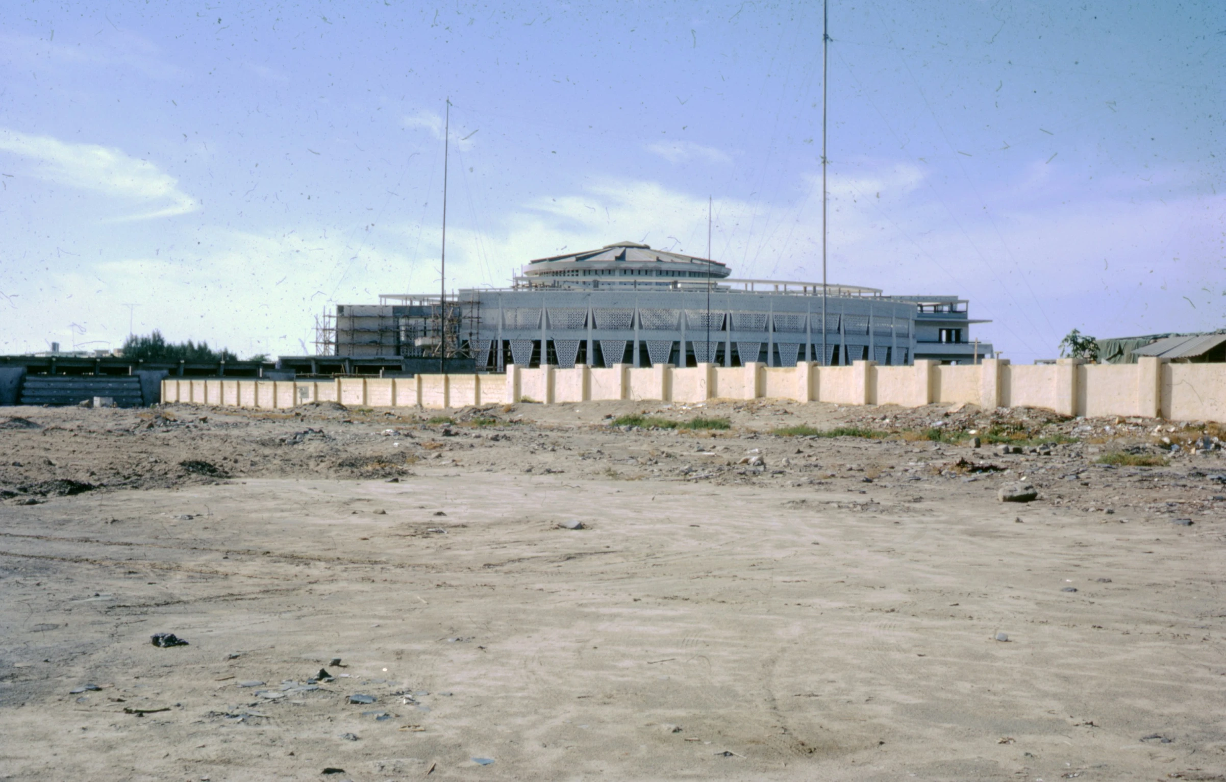 an unfinished field with buildings in the background