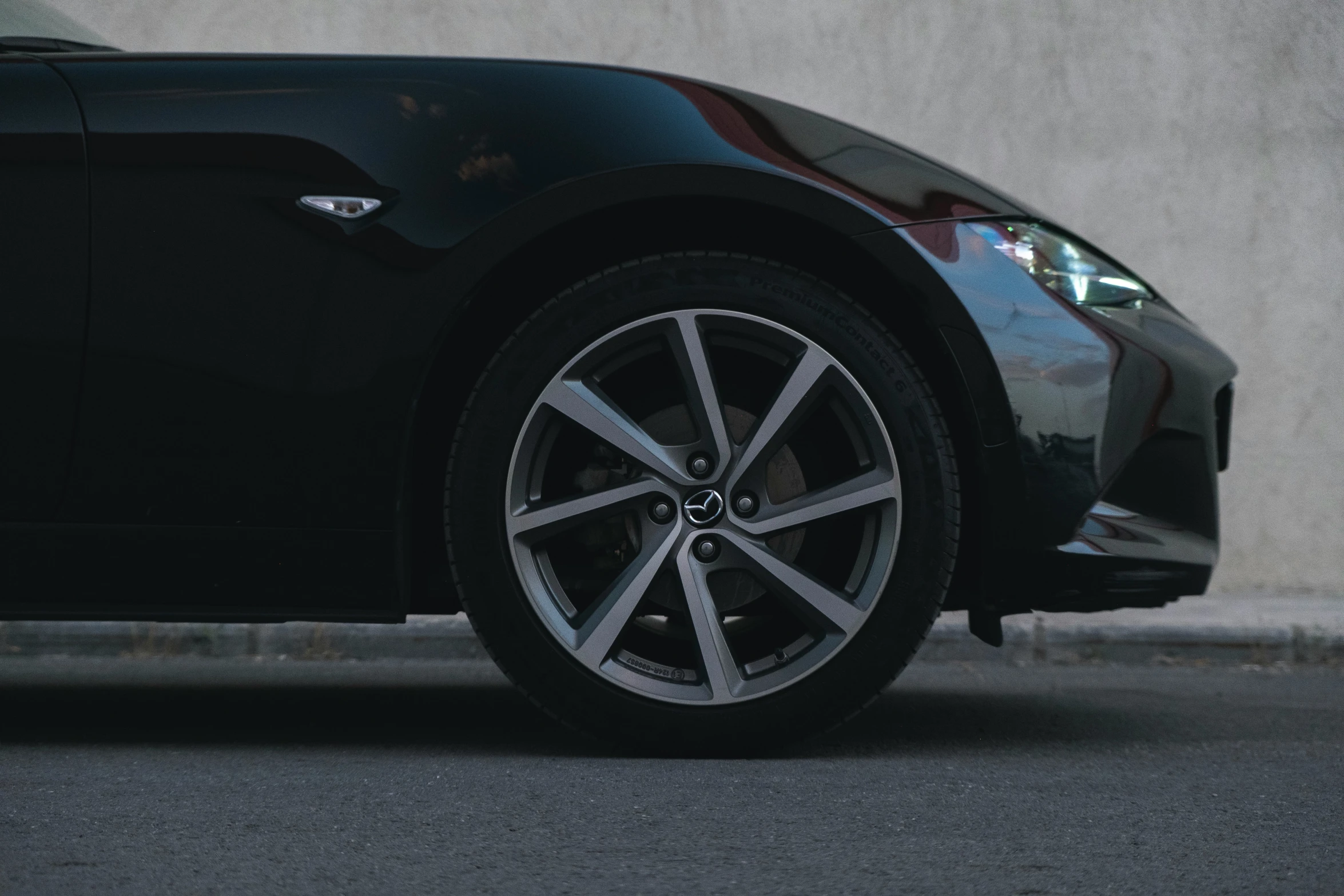 the front view of a black and silver car on concrete