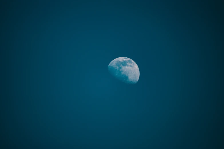 a bright blue moon shines in the night sky