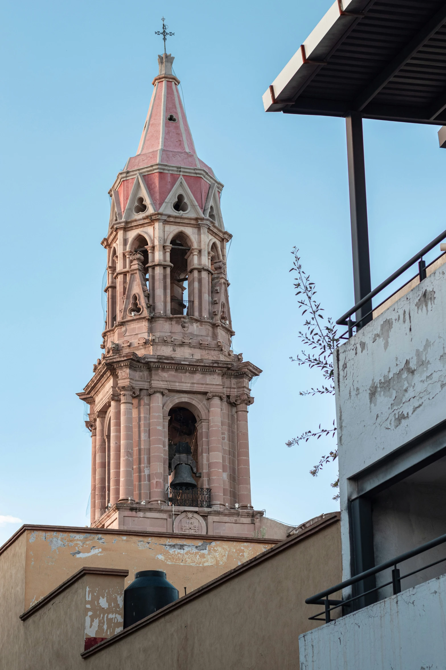 a building with a spire made from brick and a clock