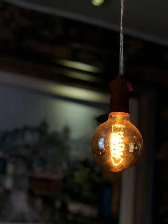 an electric light bulb that is glowing on the ceiling