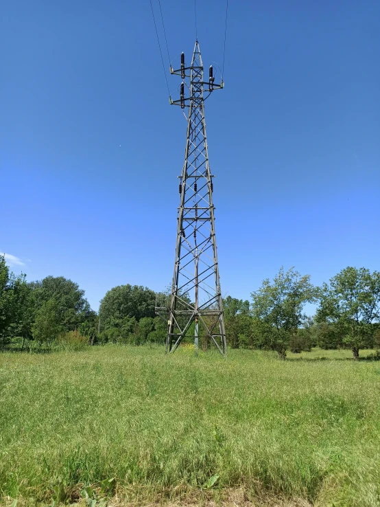 the metal tower stands in a grassy field