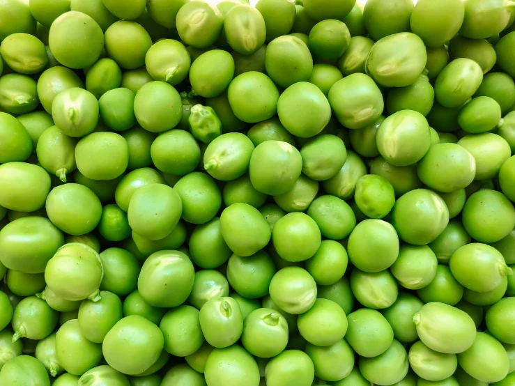an arrangement of green apples are stacked up on each other