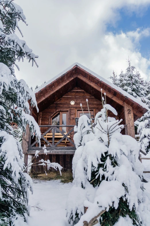 a cabin sitting in the middle of the woods covered in snow