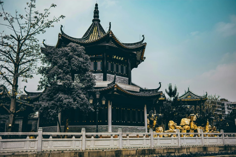 an old fashioned pagoda building stands in the middle of a park