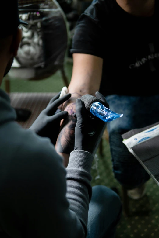 two men working on soing with gloves on their hands