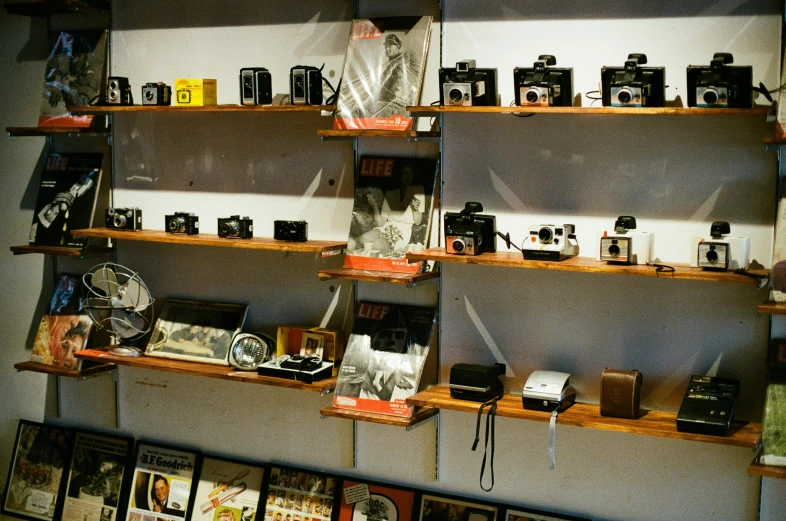 many shelves that have old fashioned cameras on them