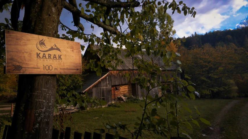 an old building with wood siding and a large sign