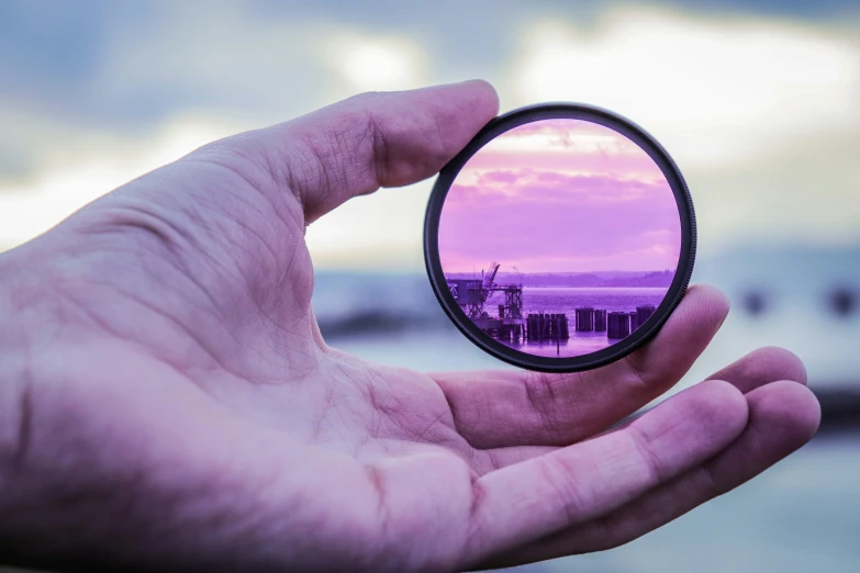 hand holding a magnifying glass looking at a building