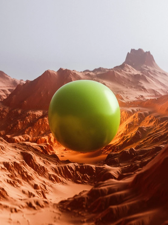 a green ball sits atop some sand in the desert