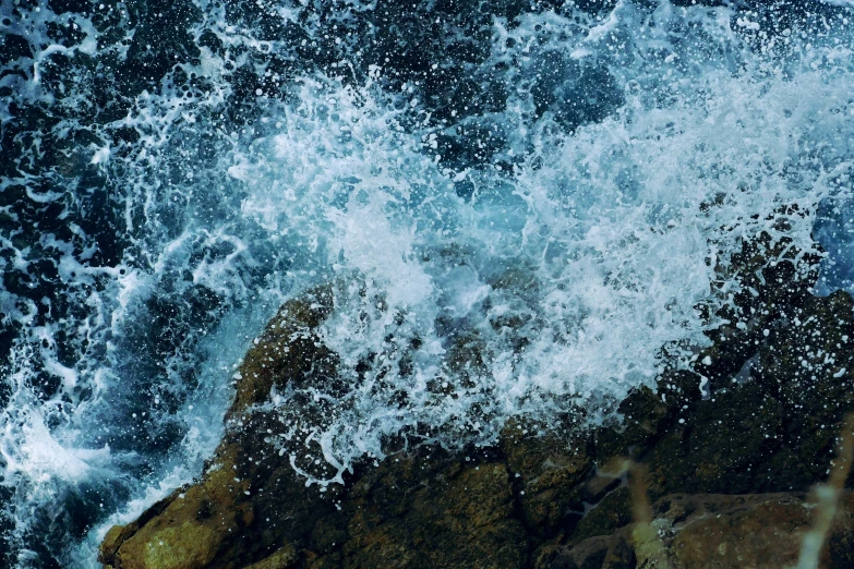 water is crashing on rocks with waves coming on them