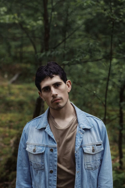 a man in the woods is standing near some trees