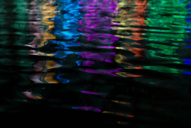 a view through the water from a bridge in rainbow colors