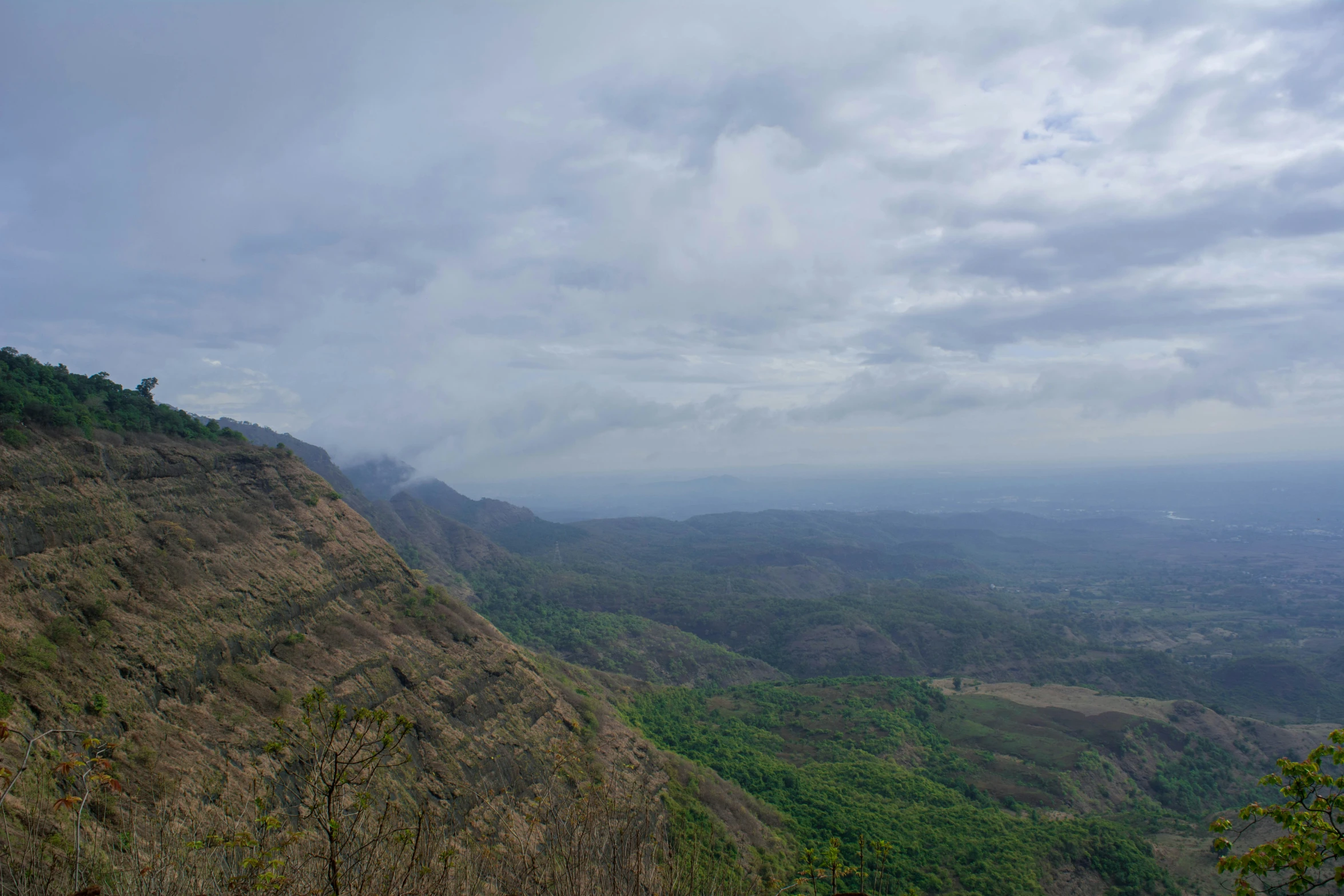 a green mountain filled with lots of brown hills