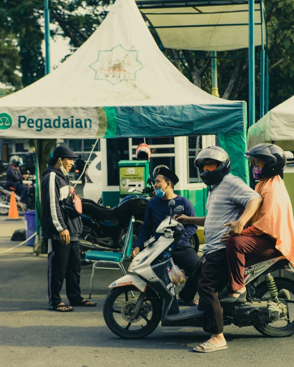 a man and two s sitting on a motorcycle