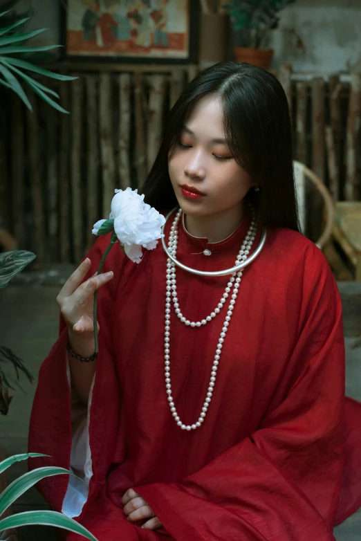 a woman in a dress holds a white flower