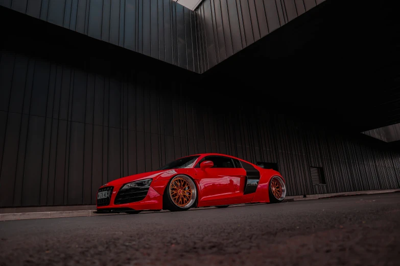 a red sport car parked in front of a building