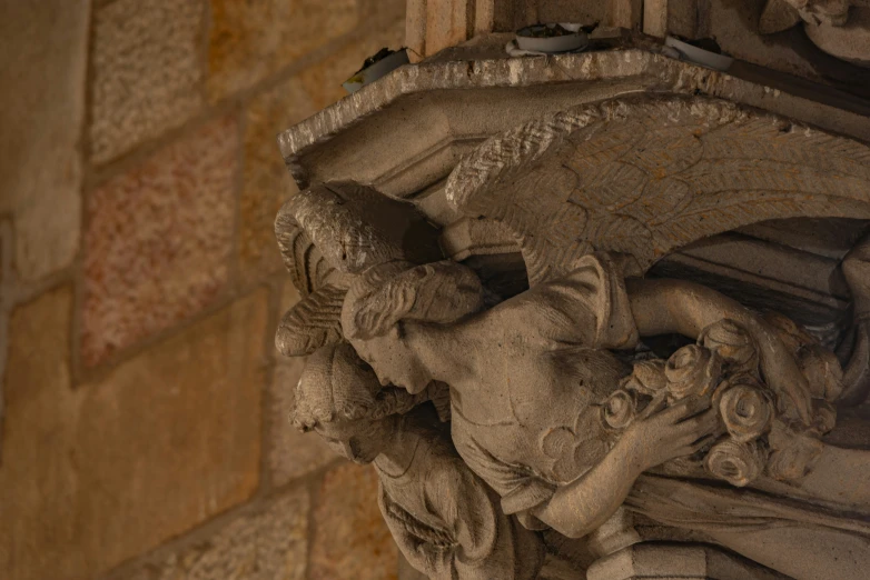 a stone sculpture near a brick wall and a wall