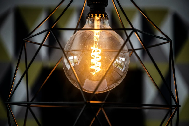 the light bulb is shining brightly through a small geometric structure