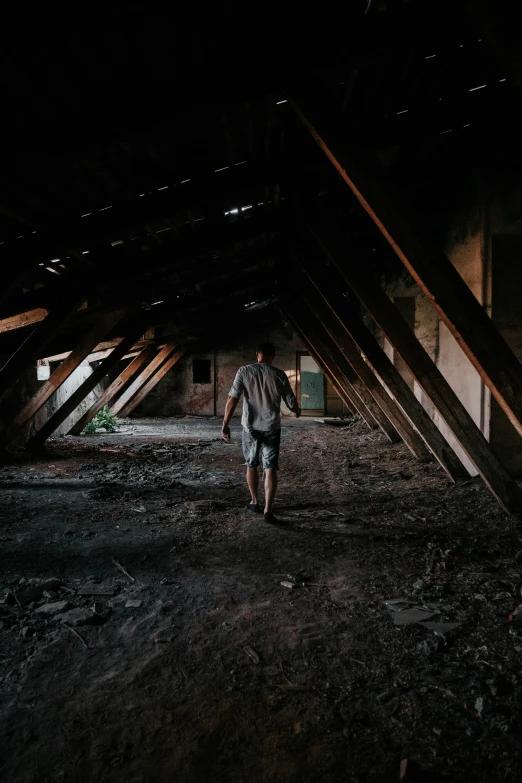 a person walking through a dirty building with stairs