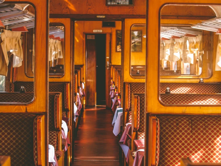 a wooden train car with windows and rows of seats