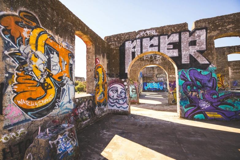 a wall is covered with colorful graffiti and has the name of the town