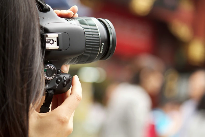 a woman holding a camera near her face