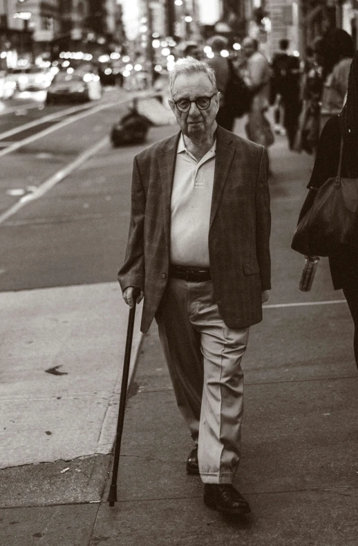 a man walking across a street holding a stick