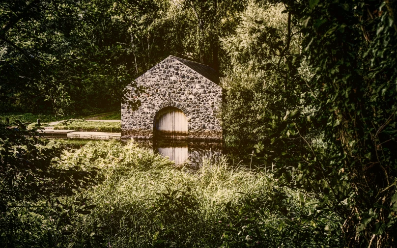 a building built out of rocks sits in a wooded area