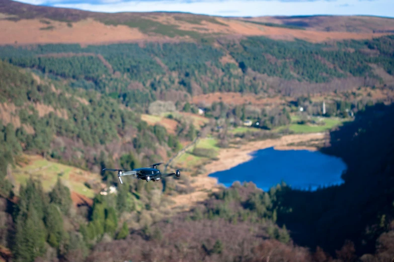 an airplane is flying in the air above a river and mountains