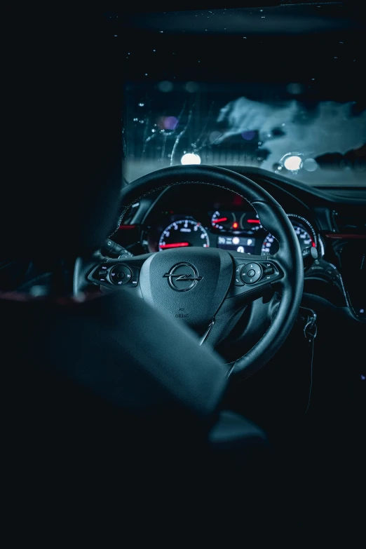 a steering wheel of a car with lights on at night