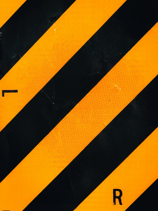 a close up of an orange, black and white hazard sign