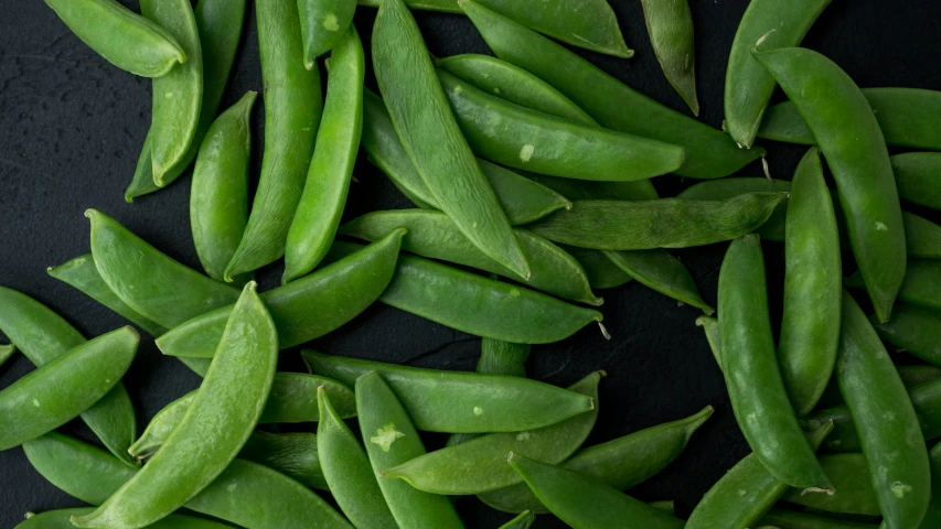 several long green peas in the middle of a bunch