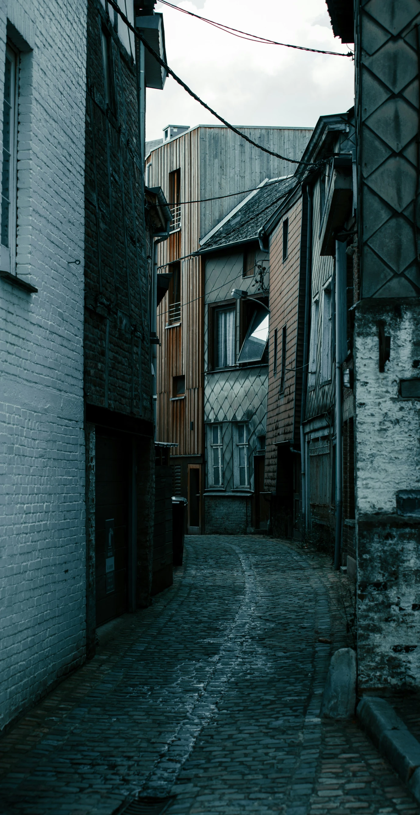 an alleyway with buildings lining the wall and cobblestones on either side