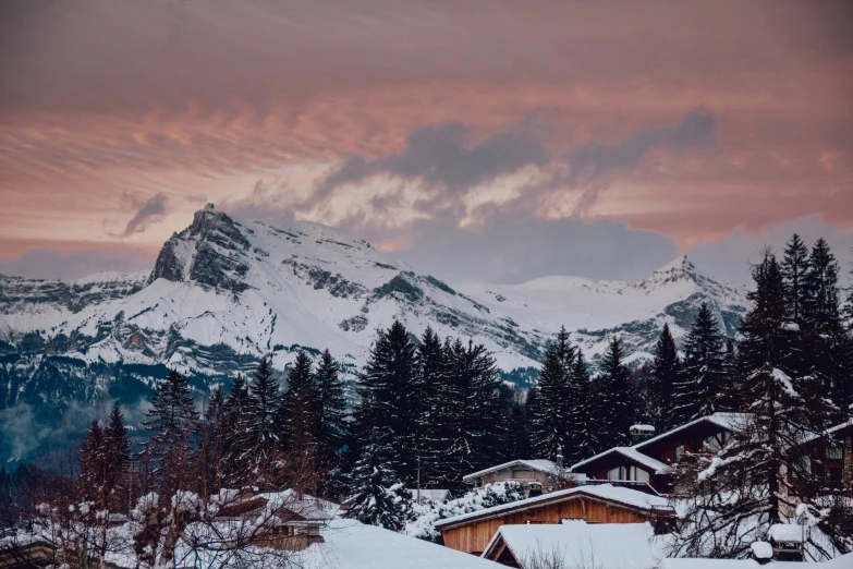 a snow covered hill in the distance and a mountain with trees