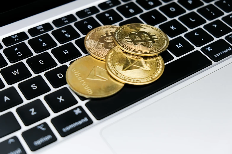 three coins are sitting on a keyboard of a laptop