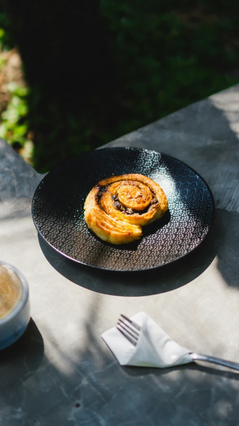 the small pastry is on a plate and next to the spoon