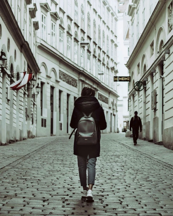 man with backpack walking down the street