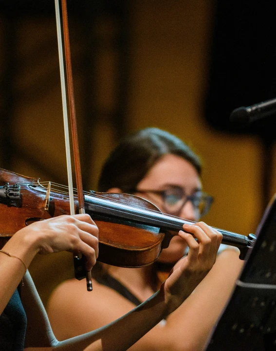 an older woman plays the violin on stage