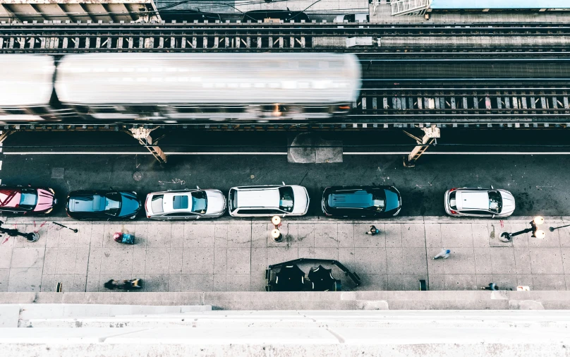 several cars parked at the sidewalk in front of a building