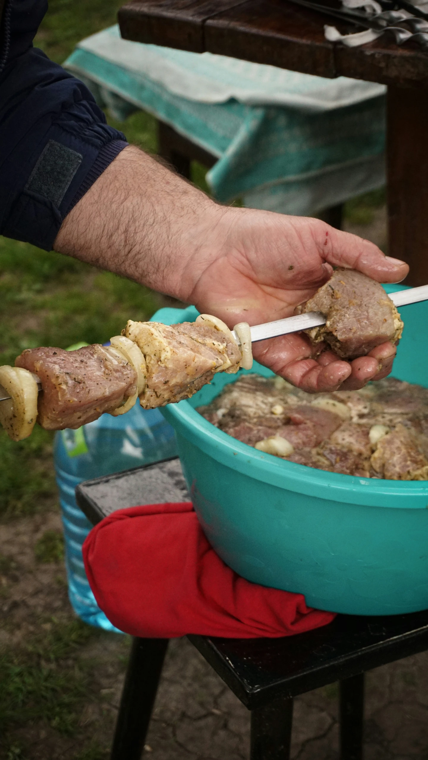 someone is taking some meat from a green dish