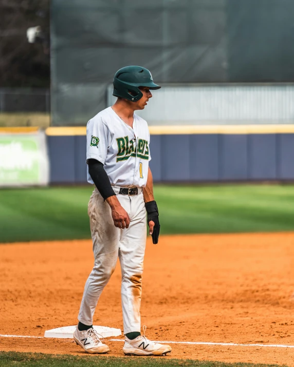 a man with a baseball glove standing on a base