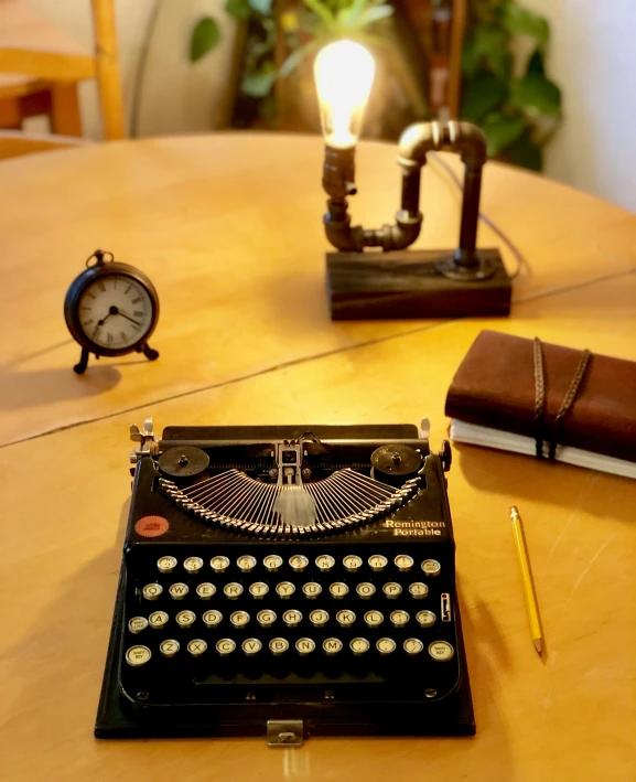 a vintage typewriter sits on a desk next to a table with a lit bulb and an alarm clock