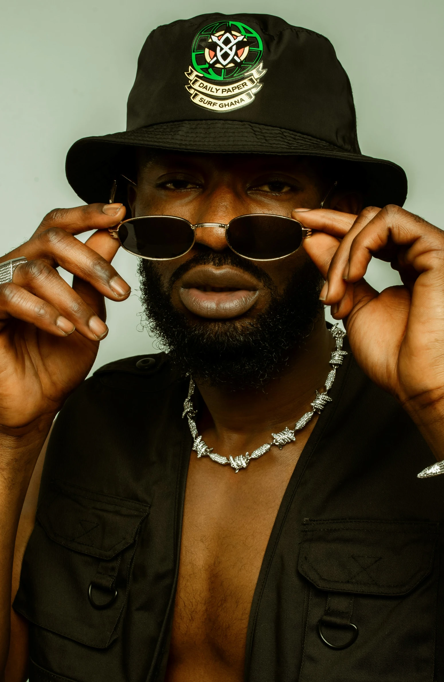 an african man is holding his sunglasses in one hand and wearing a hat in the other