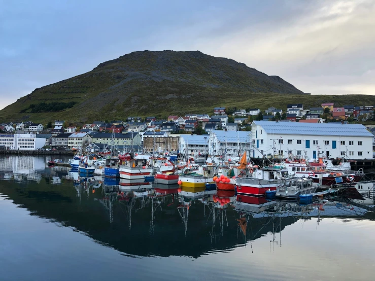 the boats are parked along the shore next to the houses