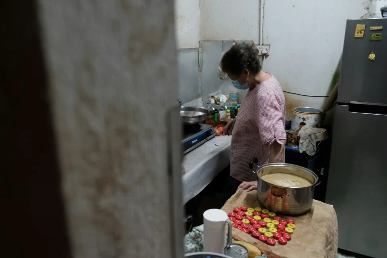 a woman cooking food in a kitchen surrounded by garbage