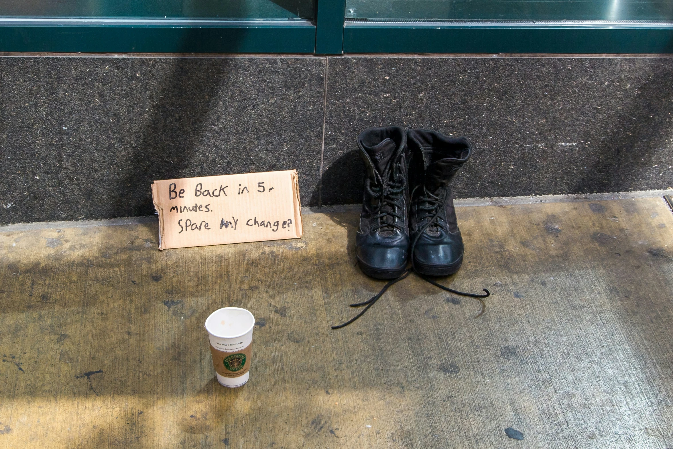 the boots are beside the cup that is on the ground