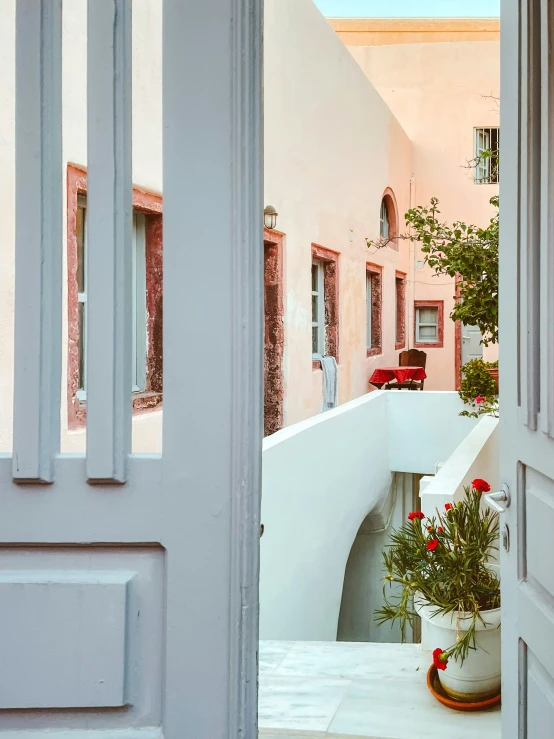 a doorway opens into an alley with houses and a street scene