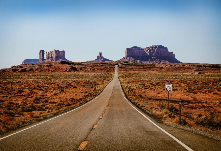 a deserted highway with a mountain in the background