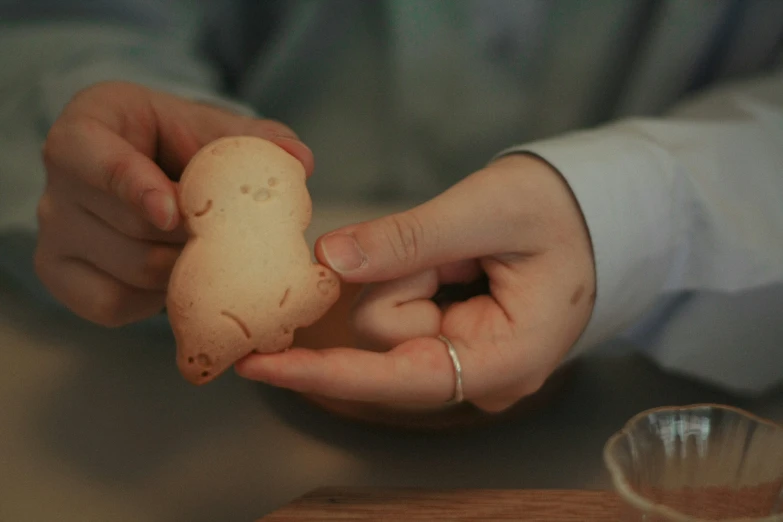 a person holding a piece of food on top of a table